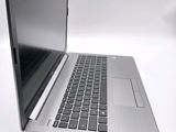 a silver laptop with a black keyboard on a white surface
