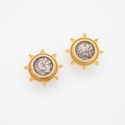 une photo d'une paire de boucles d'oreilles représentant des pièces de monnaie romaines en or et en argent