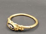 gros plan d'une bague en or avec une pierre au milieu