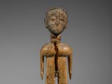 une figurine en bois représentant un homme avec une cravate sur la poitrine