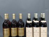 un groupe de six bouteilles de vin assises les unes à côté des autres