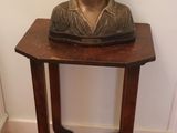 a small wooden table with a statue of a woman on it