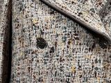 the jacket is made of tweed and has buttons on the collar