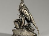 silver plate sculpture of a pheasant perched on a branch