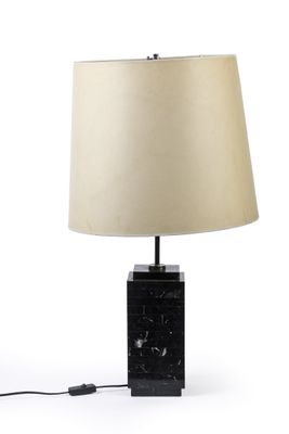 une lampe de table en marbre noir avec un abat-jour beige sur fond blanc
