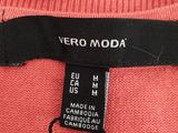 a close up of a pink sweater with a black label on it