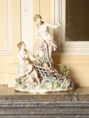 une figurine posée sur une table près d'une fenêtre