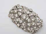 a close up of a diamond broochle on a white surface