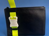 a hand holding a black wallet with a yellow strap