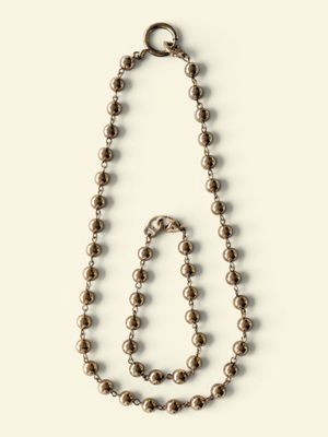 a close up of a necklace and a bracelet on a white surface