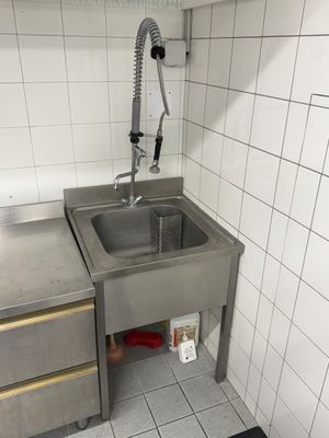 un évier avec robinet dans le coin d'une cuisine