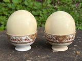 two eggs sitting on top of a table next to each other