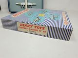 a box of dinky toys sitting on a table next to a suitcase