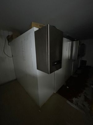 a refrigerator in the middle of a room that is being remodeled