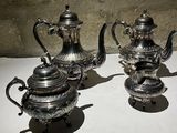three silver teapots sitting next to each other on a table