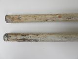 pair of wooden baseball bats on a white surface with a white background