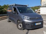 une camionnette Citroën garée sur le bord de la route, devant un immeuble