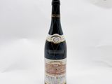 une bouteille de vin posée sur une table blanche