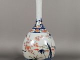 a white vase with a blue and orange design on it