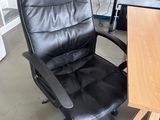 a black office chair sitting in front of a wooden desk