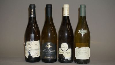 quatre bouteilles de vin sont alignées sur une table