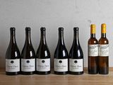 six bouteilles de vin sont alignées sur une table en bois