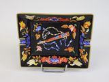 assiette noire et dorée ornée d'un motif représentant un oiseau et des fleurs