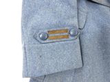 a close up of a blue jacket with a wooden button on it