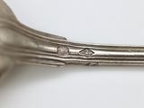 a silver spoon and a fork on a white table