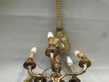 an antique brass chandelier with five lights and a flower