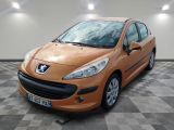 La voiture orange est garée dans le garage, sur le sol à damier.