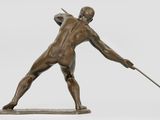bronze statue of a man holding a spear and a stick