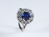 a close up of a blue sapphire and diamond ring on a white background