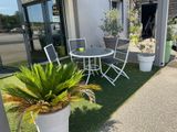 une table et des chaises posées sur l'herbe devant un bâtiment