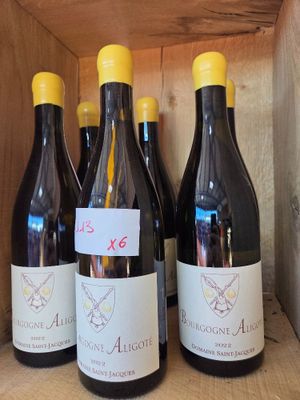 Plusieurs bouteilles de vin sont alignées dans une caisse en bois