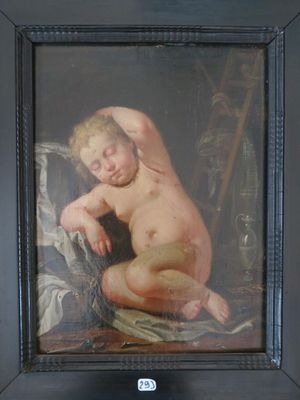 painting of a naked child in a black frame on a table