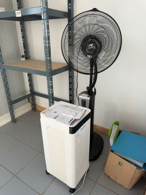 an image of a fan in a room next to a stack of books