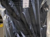 a black umbrella wrapped in a plastic bag on the floor