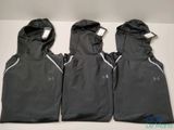 Trois gilets Under Armour pour homme sont alignés sur une table