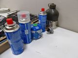 many cans of blue and white spray paint on a table