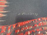 a close up of a red and black rug on a table