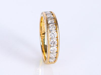 a close up of a gold and diamond ring on a white surface