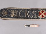 a scarf with a cross on it and some other items on the table