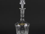 a crystal decanter with a stopper on a black background