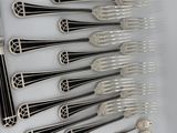 a lot of silverware on a table with a knife and spoon