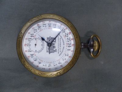 une montre de poche en or posée sur une surface grise