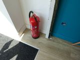 a red fire extinguisher next to a blue door