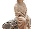 a small statue of a boy sitting on top of a rock