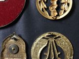 three gold medals and a red box on a black surface