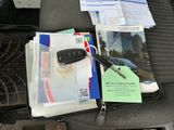 un siège auto avec une pile de papiers et un téléphone portable